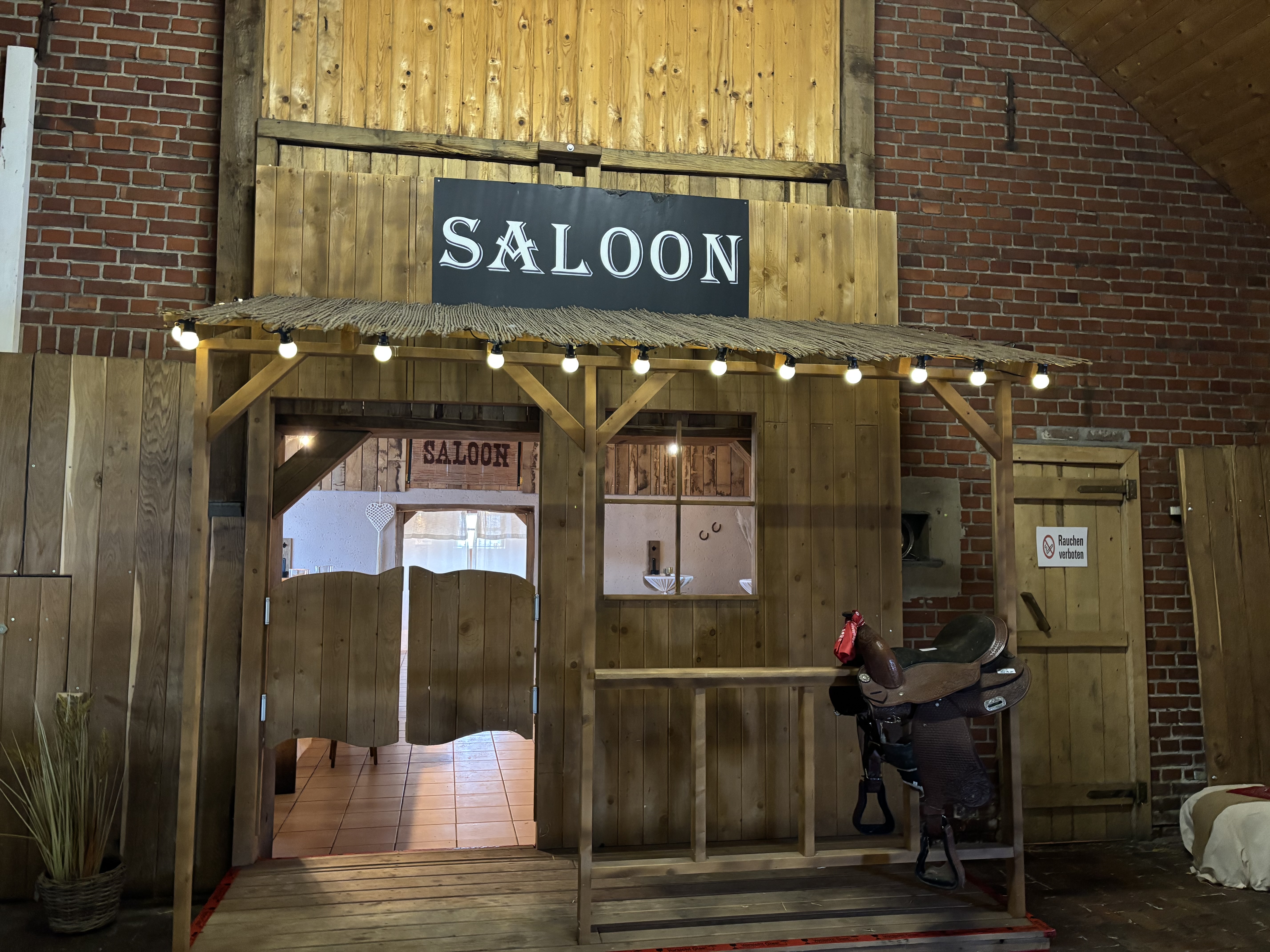 Saloon-Eingang der Festscheune mit Schwingflügeltüren und Lichterketten